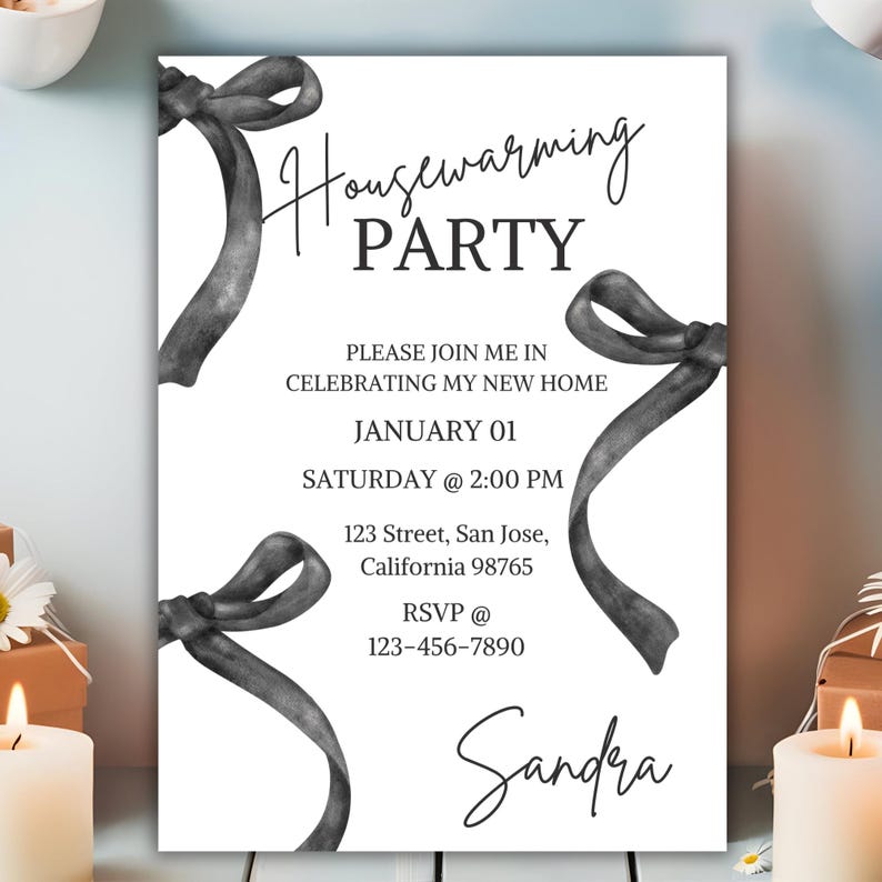 May include: Black and white housewarming party invitation with a handwritten font. The invitation features a decorative ribbon design and the text "Housewarming Party", "Please join me in celebrating my new home", "January 01", "Saturday @ 2:00 PM", "123 Street, San Jose, California 98765", "RSVP @ 123-456-7890", and "Sandra".