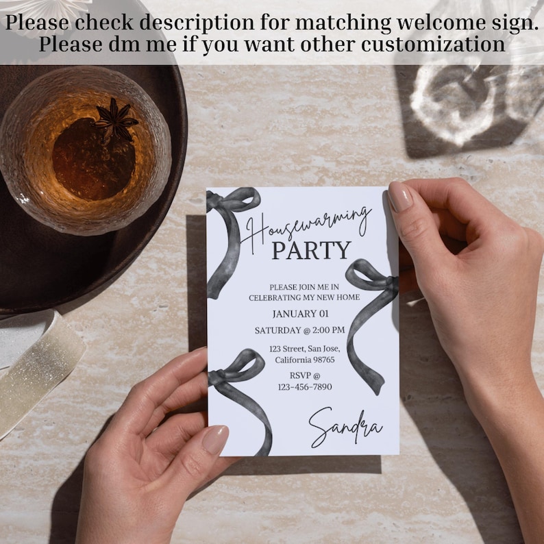 May include: A white housewarming party invitation with black watercolor ribbons and the text "Housewarming Party". The invitation includes the date, time, address, and RSVP information. The name "Sandra" is written at the bottom of the invitation.
