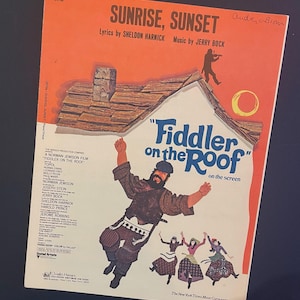 May include: Sheet music for "Sunrise, Sunset" from the musical "Fiddler on the Roof." The cover features a colorful illustration of a man dancing on a roof, with other figures below. The title is in large, bold letters.