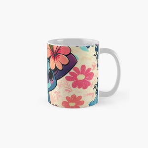 May include: A white ceramic mug with a colorful floral pattern and a cartoon character wearing a flower crown. The character is blue with purple accents and has large eyes. The mug is a standard size and has a handle on the right side.