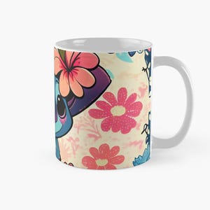 May include: A white ceramic mug with a colorful design featuring a blue cartoon character with pink flowers and butterflies. The character is wearing a purple hat with pink flowers.