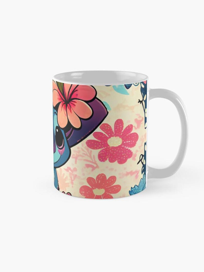 May include: A white ceramic mug with a colorful design featuring a blue cartoon character with pink flowers and butterflies. The character is wearing a purple hat with pink flowers.