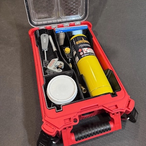 May include: A red plastic tool organizer case with a clear hinged lid, containing a yellow Bernzomatic fuel cylinder, a white circular container, a metal pipe cutter, a wire brush, a marker, and a small blue plastic component organizer tray.