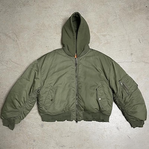 May include: An olive green bomber jacket with a matching attached hood, a full-length front zipper, two side pockets with snap closures, a zippered utility pocket on the left sleeve, and ribbed cuffs and hem with a gathered sleeve design.