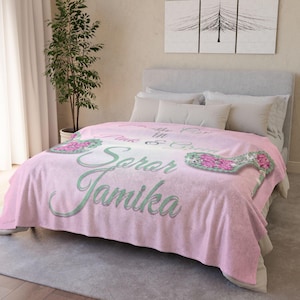Op de afbeelding: Een roze en groene fleece deken met de tekst "The Pink & Green Soror Jamika" erop gedrukt.