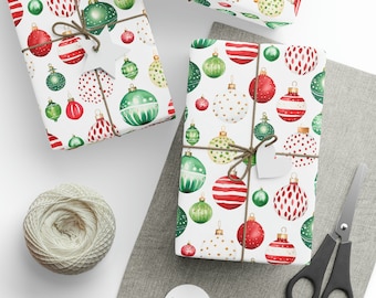 Puede incluir: Regalos envueltos con patrones festivos de adornos navideños en rojo, verde y dorado sobre un fondo blanco. Los regalos están atados con hilo y adornados con etiquetas. También se ven un carrete de hilo, tijeras y etiquetas en blanco.