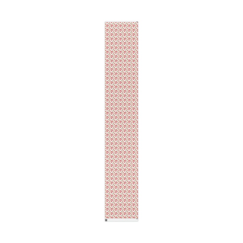May include: A white fabric with a repeating pattern of small red flowers and green leaves.