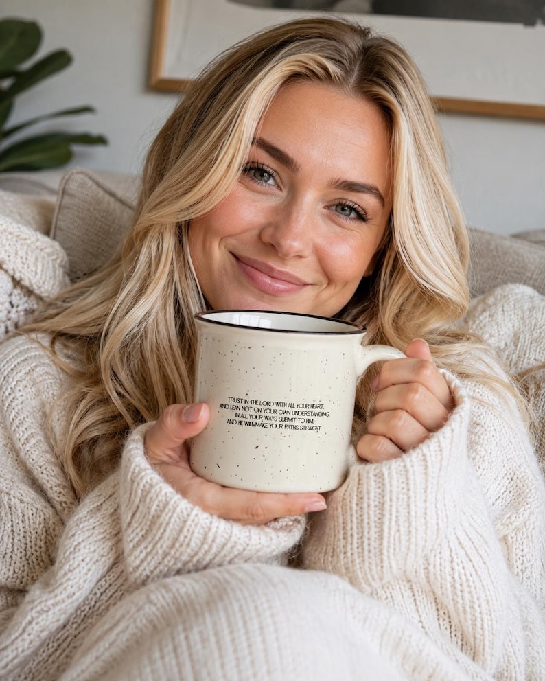 May include: A cream-coloured ceramic mug with a speckled finish and a black rim. The mug features black printed text that reads: Trust in the Lord with all your heart and lean not on your own understanding; in all your ways submit to him, and he will make your paths straight.