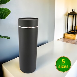 May include: A black cylindrical container with a silver band around the top. The container is sitting on a white surface. 5 sizes.