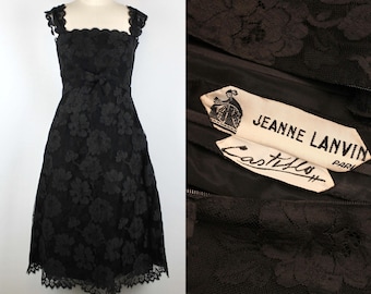 Puede incluir: Un vestido negro de encaje con estampado floral y una etiqueta que dice "Jeanne Lanvin Paris Castilly".