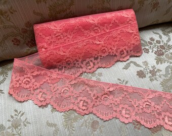 May include: A close-up of a pink lace trim with a delicate floral pattern. The lace is soft and flowing, and it would be perfect for adding a touch of elegance to any project.
