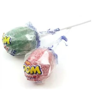May include: Two individually wrapped lollipops, one green and one red, with the word "WOO!" printed on the wrappers. The lollipops are on white sticks.
