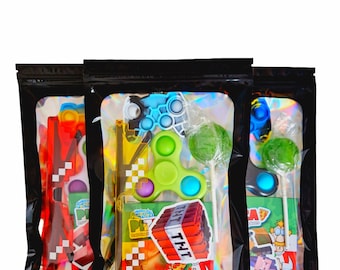 May include: Three black zipper bags filled with colorful toys and candy. Each bag contains a variety of items, including fidget toys, lollipops, and stickers. The bags have a holographic interior and are set against a white background.