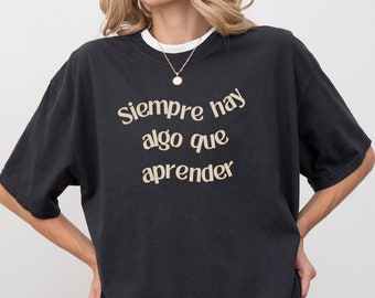 T-shirt per l'educazione doppia lingua - T-shirt 'Siempre hay algo que aprender' con tipografia ondulata