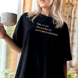 May include: Black t-shirt with the text "Hoy es un dia perfecto para matemáticas" in rainbow colors.