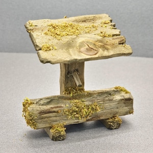 Peut inclure: Un abreuvoir miniature en bois avec un toit en bois, tous deux recouverts de mousse. L'abreuvoir est soutenu par deux pieds en bois.