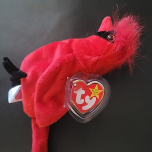 Könnte beinhalten: Rotes Plüsch-Kardinal-Beanie Baby Spielzeug mit schwarzem Schnabel und einem roten und gelben Ty-Herz-Etikett mit der Aufschrift "Beanie Babies" und "Ty".