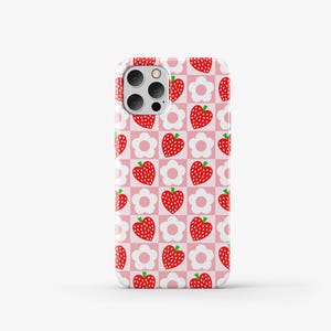 May include: A pink phone case with a repeating pattern of red strawberries and white flowers.