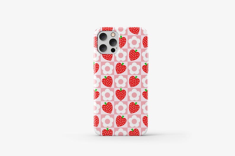 May include: A pink phone case with a repeating pattern of red strawberries and white flowers.