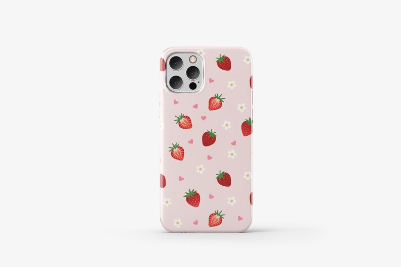 May include: A pink phone case with a pattern of strawberries and hearts. The case has a clear camera cutout and a white border.
