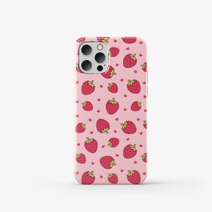 May include: A pink phone case with a pattern of red strawberries and white hearts.