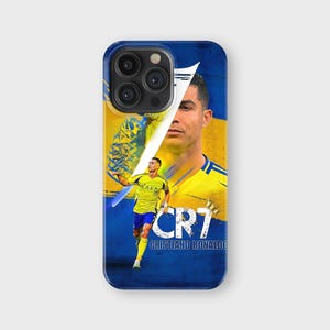 May include: A blue phone case featuring a portrait of Cristiano Ronaldo with a yellow and blue background. The case has the text "CR7" and "Cristiano Ronaldo" in white.