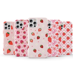 May include: Five different phone cases with a pink background and a pattern of red strawberries. The cases are all for the same model phone and have different patterns of strawberries.