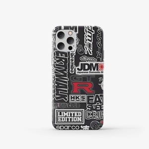 May include: Black iPhone case with a white and red graphic print of Japanese car racing and tuning logos, including "JDM", "GT-R", "HKS", "Brembo", "Sparco", "Drift", and "Limited Edition".