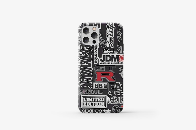 May include: Black iPhone case with a white and red graphic print of Japanese car racing and tuning logos, including "JDM", "GT-R", "HKS", "Brembo", "Sparco", "Drift", and "Limited Edition".