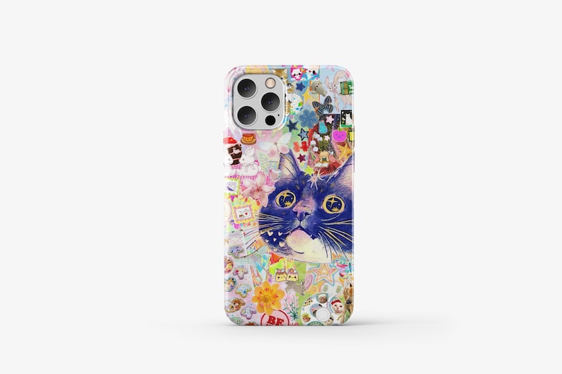 May include: A colourful phone case featuring a collage of stickers and a blue cat with yellow eyes. The cat is the main focus of the design and is looking directly at the viewer.