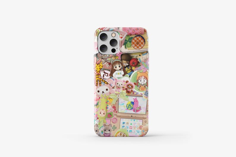 May include: A pink and white phone case featuring a colourful collage of cartoon characters, animals, and objects. The case has a pink and white background with a variety of colourful stickers and illustrations.