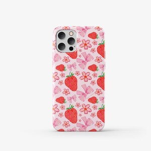 May include: A pink phone case with a pattern of strawberries, flowers, and bows.
