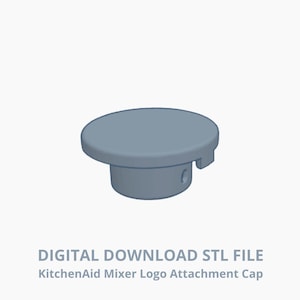 Könnte beinhalten: Eine hellgraue KitchenAid Mixer Logo-Aufsatzkappe. Die Kappe ist rund mit einer flachen Oberseite und einem zylindrischen Sockel. Der Text "DIGITAL DOWNLOAD STL FILE" befindet sich darunter.