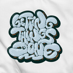 Könnte beinhalten: Ein weißes T-Shirt mit einem blauen und orangenen Design, auf dem "Getting Things Done" steht.
