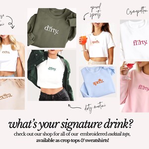 May include: A collage of photos showing different embroidered sweatshirts and crop tops with various cocktail names, such as "dirty martini", "spritz", "flirty", and "extra". The text "what's your signature drink?" is at the bottom of the image.