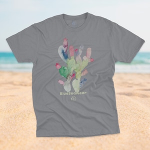 May include: A gray t-shirt with a watercolor cactus design in shades of green, pink, and blue. The text "BlueSeaWear" is printed below the cactus.