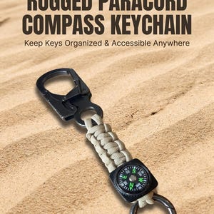 May include: A keychain featuring a black metal carabiner, a tan paracord braided section, and a small square black compass with green directional markings. The text DESERT FOX RUGGED PARACORD COMPASS KEYCHAIN Keep Keys Organized & Accessible Anywhere is visible.