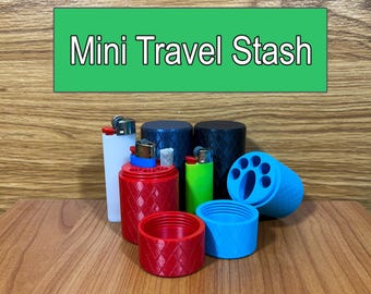 Può includere: Mini Travel Stash, un set di piccoli contenitori per riporre oggetti, tra cui un contenitore rosso con un motivo a rombi, un contenitore blu con un design a forma di zampa e un contenitore nero con un accendino all'interno.