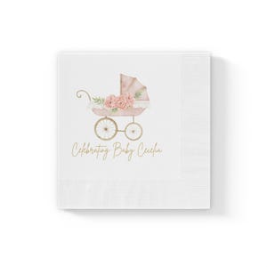 Puede incluir: Servilleta de papel blanca con un cochecito de bebé rosa y dorado adornado con flores y el texto "Celebrating Baby Cecilia".