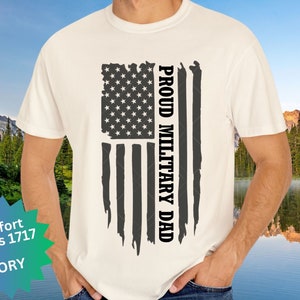 Könnte beinhalten: Ein weißes T-Shirt mit einem abgenutzten amerikanischen Flaggen-Design und dem Text "Proud Military Dad".