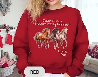 May include: Red sweatshirt with the text "Dear Santa, Please bring horses! Love, Me" and a graphic of three horses in shades of brown and tan. The word "RED" is at the bottom.