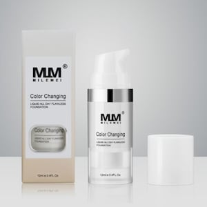 Op de afbeelding: Een doorzichtige vloeibare foundationfles en -doos met de tekst "MM MILEMEI Color Changing Liquid All Day Flawless Foundation". De fles heeft een zilveren band en een witte pomp. De doos is beige.