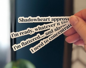 Peut inclure: Quatre autocollants blancs avec du texte noir. Le texte dit "Shadowheart approve", "I'm ready, whatever it takes", "I'm flattered... and alarmed", et "I need to concentrate".