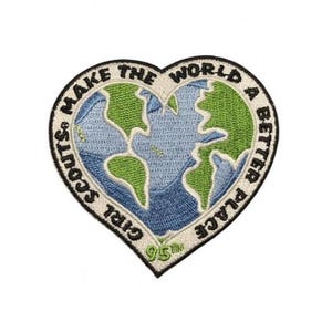 Pode incluir: Um emblema bordado em forma de coração com um design de globo azul e verde. A borda é de cor creme com texto preto que diz GIRL SCOUTS MAKE THE WORLD A BETTER PLACE. O número 95th está bordado em verde na ponta inferior.