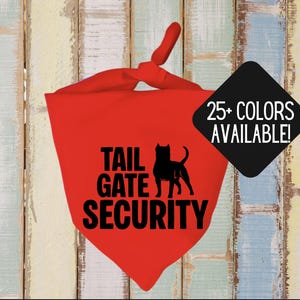 May include: A red dog bandana with the text "TAIL GATE SECURITY" and a black silhouette of a dog. A black diamond shape with the text "25+ COLORS AVAILABLE!" is in the upper right corner. The bandana is knotted at the top.