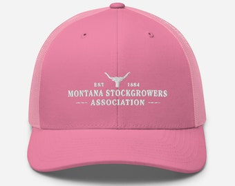 Może przedstawiać: Różowa i czarna czapka trucker z białym haftowanym logo z napisem "EST 1884 MONTANA STOCKGROWERS ASSOCIATION".