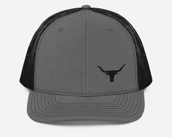 Może przedstawiać: Szara i czarna czapka trucker z haftowanym czarnym wzorem głowy byka longhorn.