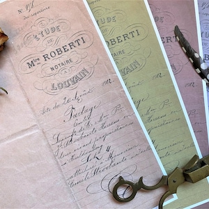 May include: Four vintage legal documents with handwritten text in French. The documents are titled "Etude de M. Roberti, Notaire a Louvain" and dated 1912. The documents are on different colored paper, including pink, green, and blue. A pair of antique scissors and a feather pen are lying on top of the documents.