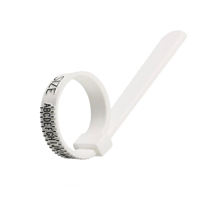May include: White plastic ring sizer with a sliding mechanism and a size chart marked with letters A through Z and the word "SIZE".