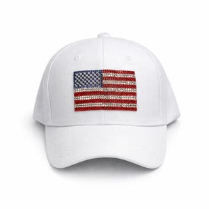 Op de afbeelding: Witte baseballpet met een sprankelend Amerikaans vlagontwerp. De vlag is gemaakt van rode, witte en blauwe strass-steentjes. De pet heeft een gebogen klep en een knoop aan de bovenkant.